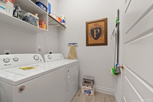 washroom with washing machine and dryer and light wood-type flooring