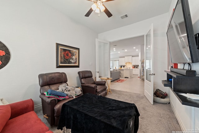 carpeted living room featuring ceiling fan