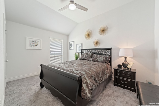 bedroom with vaulted ceiling, light colored carpet, and ceiling fan