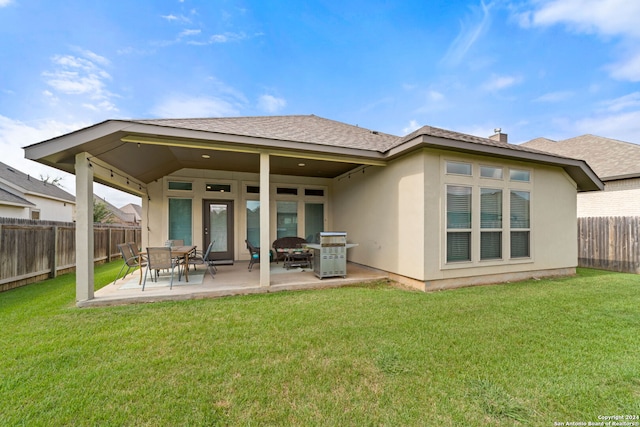 rear view of property featuring a yard and a patio