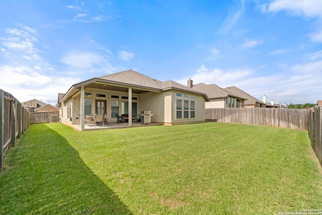 rear view of property with a lawn and a patio