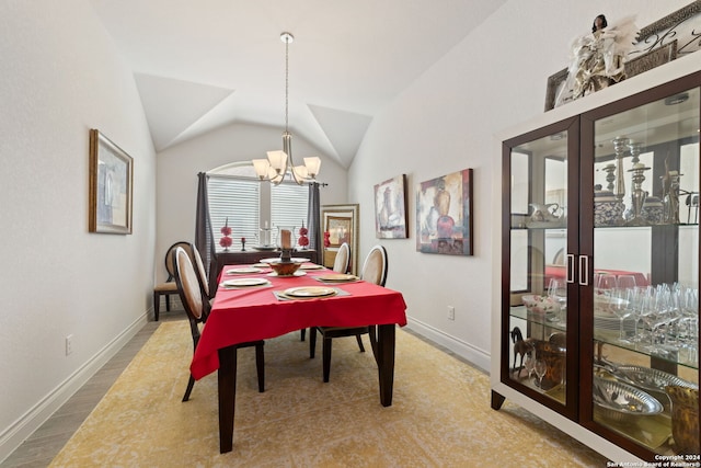 dining area with lofted ceiling and a chandelier