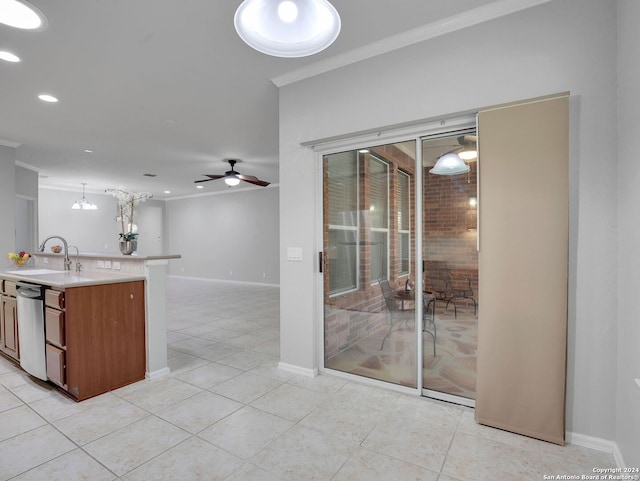 kitchen featuring pendant lighting, ceiling fan with notable chandelier, ornamental molding, light tile patterned floors, and sink