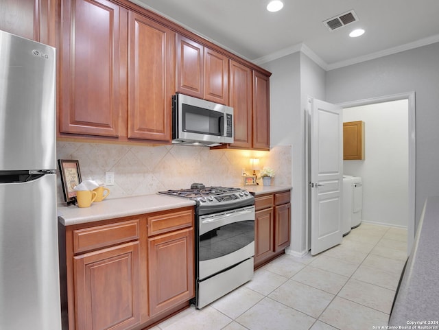 12526 Rapids Pass, San Antonio, TX 78253 - kitchen featuring appliances with stainless steel finishes, crown molding, washer and clothes dryer, light countertops, and tasteful backsplash