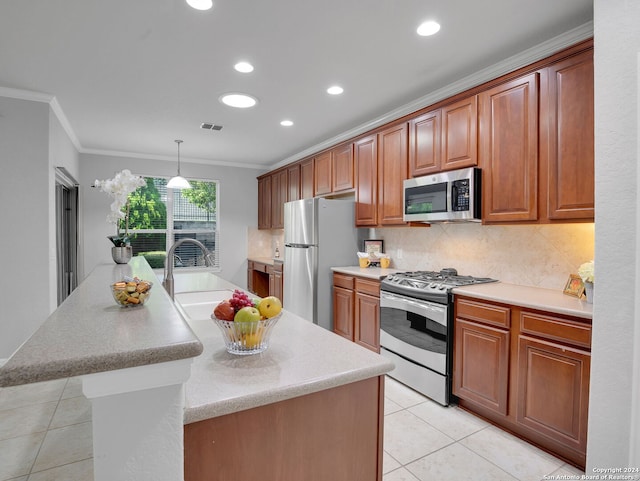 kitchen featuring crown molding, a center island, decorative light fixtures, and stainless steel appliances