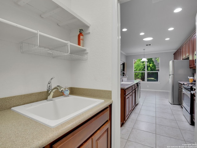 kitchen with pendant lighting, stainless steel appliances, ornamental molding, and sink