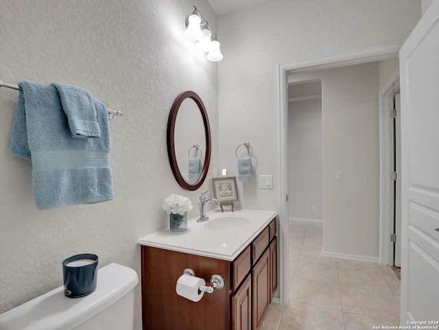 bathroom featuring tile patterned flooring, toilet, and vanity