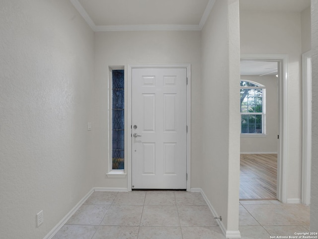 entryway with light hardwood / wood-style floors and ornamental molding