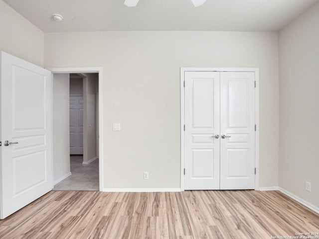 unfurnished bedroom with light hardwood / wood-style flooring, ceiling fan, and a closet