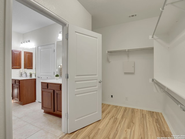 walk in closet featuring light hardwood / wood-style flooring and sink