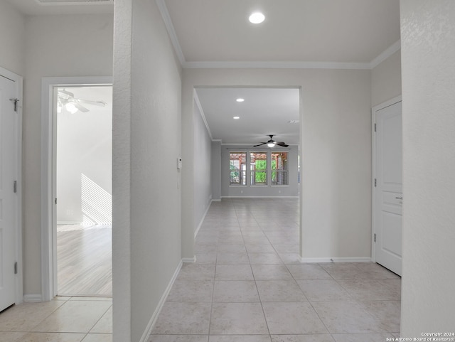 corridor with crown molding and light tile patterned flooring