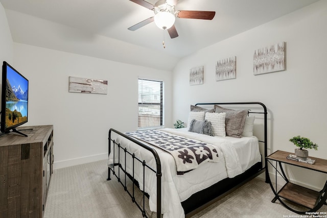 bedroom featuring ceiling fan, vaulted ceiling, baseboards, and light carpet
