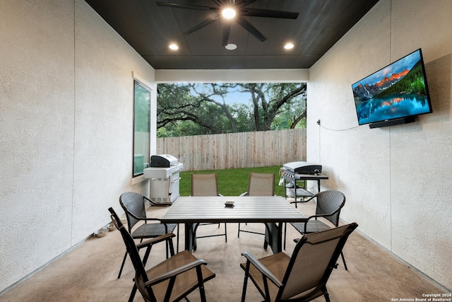 view of patio featuring a grill, fence, outdoor dining space, and ceiling fan