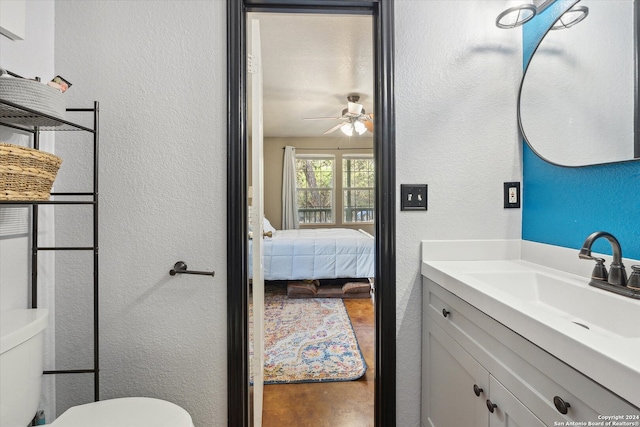 bathroom featuring vanity, toilet, and ceiling fan