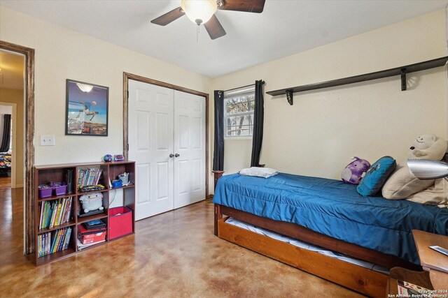 bedroom with a barn door, ceiling fan, and a closet