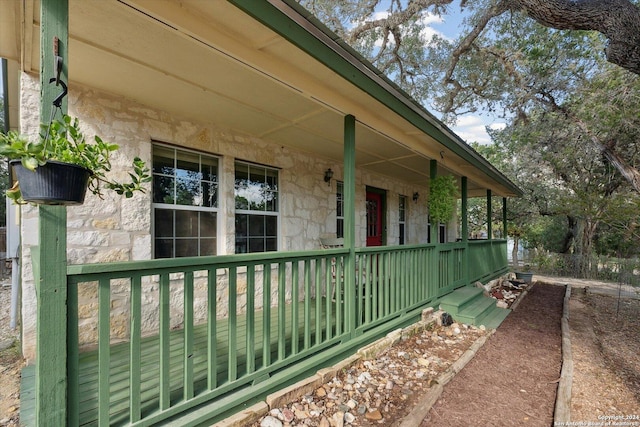 exterior space featuring a porch and stone siding