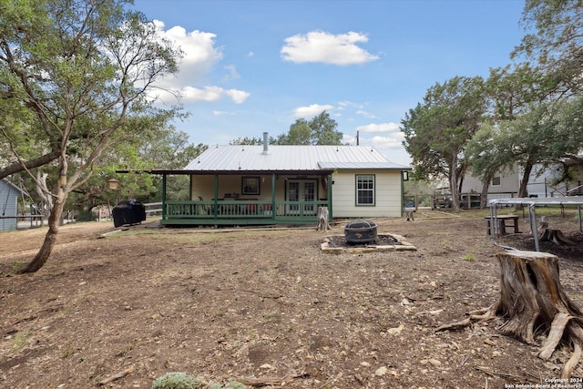 back of property featuring a deck and an outdoor fire pit