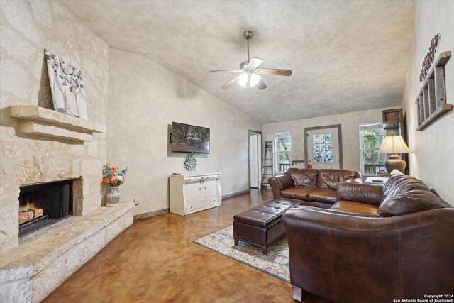 living room with concrete floors, ceiling fan, high vaulted ceiling, and a fireplace