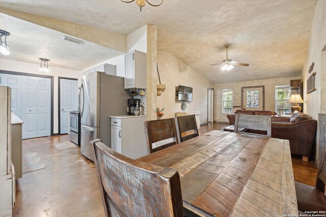 dining room featuring lofted ceiling, ceiling fan, and concrete flooring