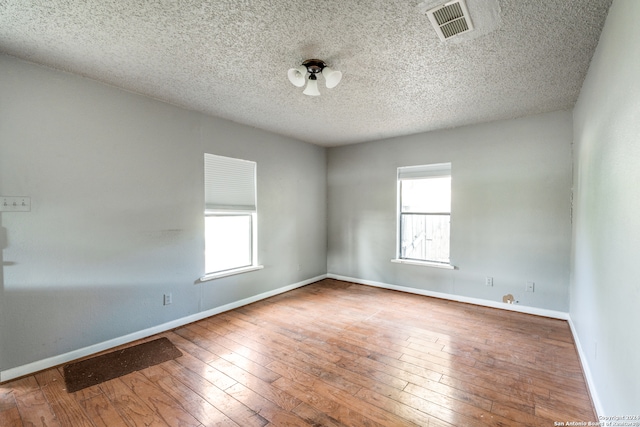 unfurnished room featuring a textured ceiling and wood-type flooring