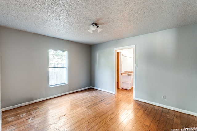 unfurnished room featuring a textured ceiling and hardwood / wood-style flooring