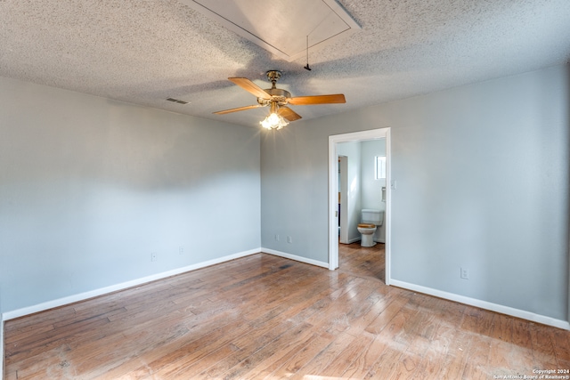 empty room with a textured ceiling, ceiling fan, and hardwood / wood-style flooring