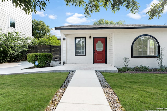 view of exterior entry with a yard