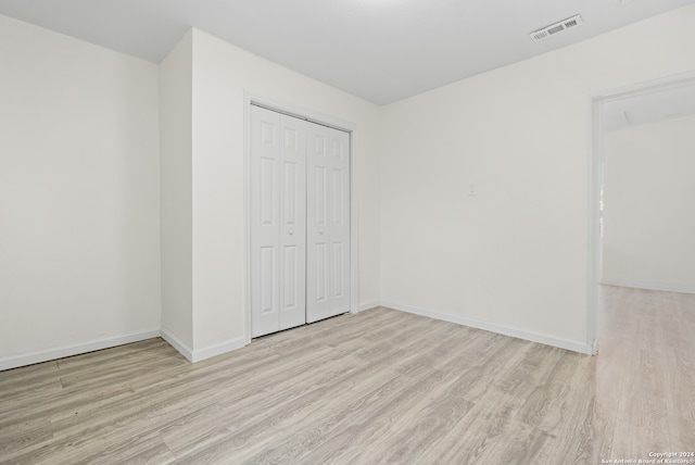 unfurnished bedroom featuring light hardwood / wood-style flooring and a closet