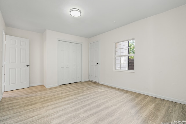 unfurnished bedroom featuring light wood-type flooring and a closet