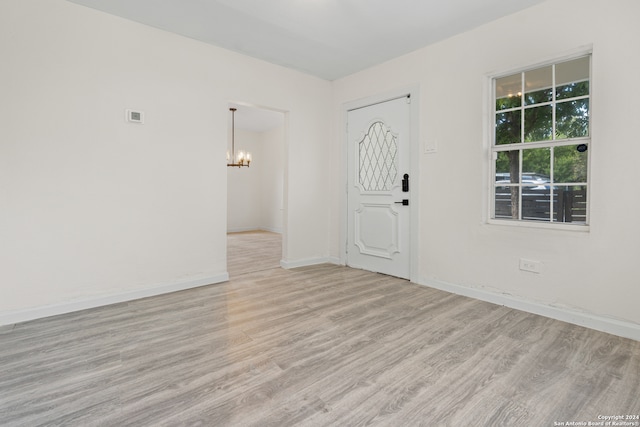 interior space with light wood-type flooring and a chandelier