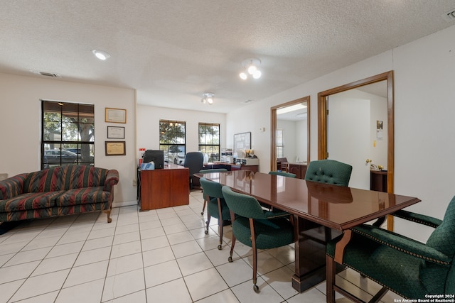 dining area featuring a textured ceiling and light tile patterned floors