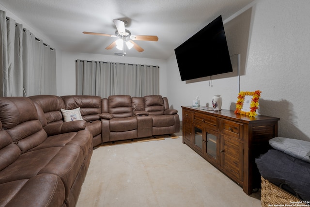 living room with ceiling fan and a textured ceiling