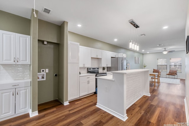 kitchen with appliances with stainless steel finishes, white cabinetry, dark wood-type flooring, ceiling fan, and a center island with sink