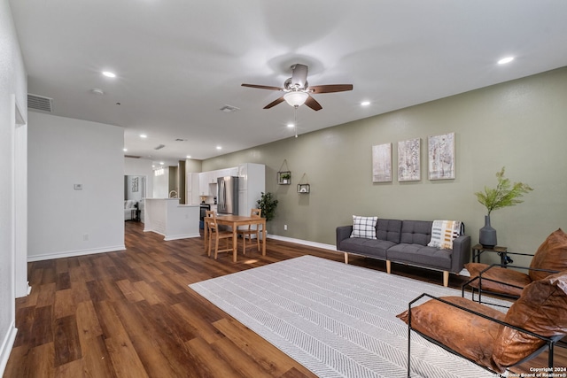 living room featuring dark wood-type flooring and ceiling fan