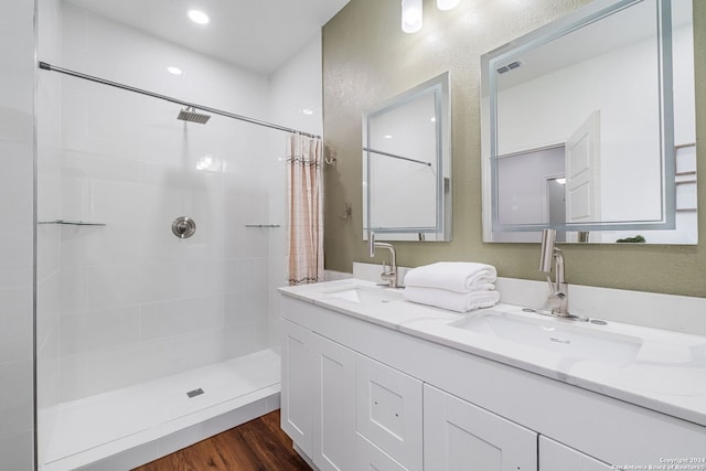 bathroom with a shower with shower curtain, hardwood / wood-style floors, and vanity