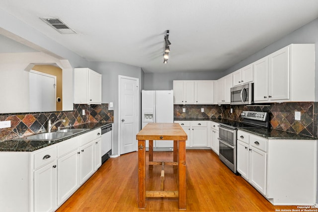 kitchen with visible vents, light wood-style floors, white cabinets, stainless steel appliances, and a sink