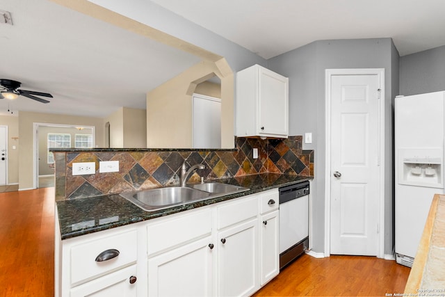 kitchen with backsplash, light wood-style floors, white cabinets, white appliances, and a sink