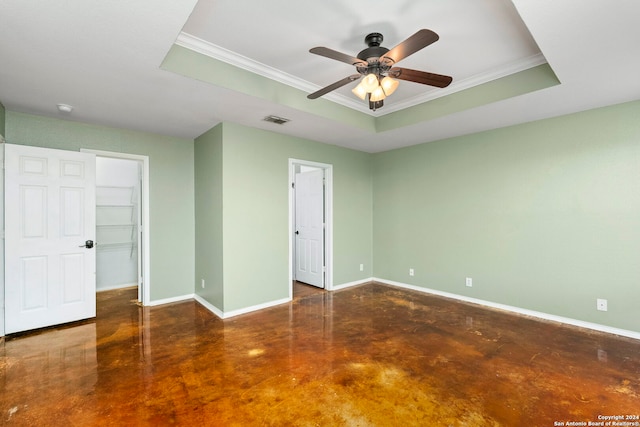 unfurnished bedroom with baseboards, visible vents, ornamental molding, concrete flooring, and a raised ceiling