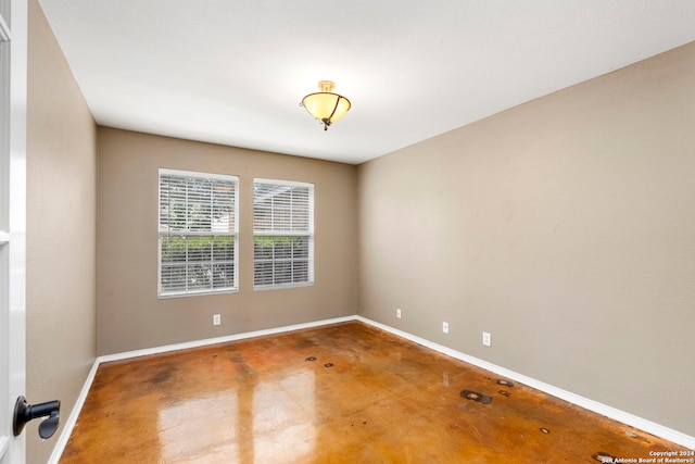 empty room featuring baseboards and concrete floors