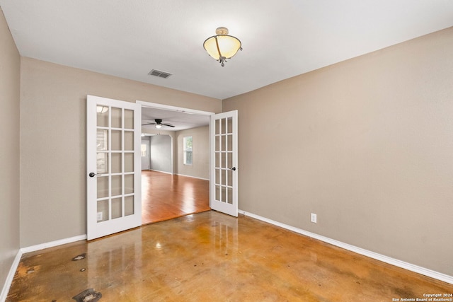 unfurnished room with concrete floors, french doors, baseboards, and visible vents