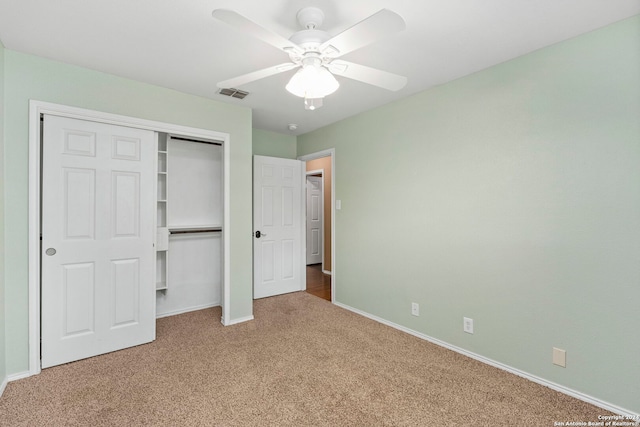 unfurnished bedroom featuring carpet, baseboards, visible vents, ceiling fan, and a closet