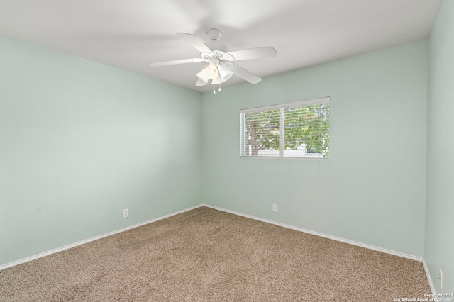 carpeted spare room with baseboards and ceiling fan