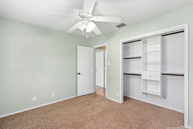 unfurnished bedroom featuring visible vents, baseboards, light colored carpet, a closet, and a ceiling fan