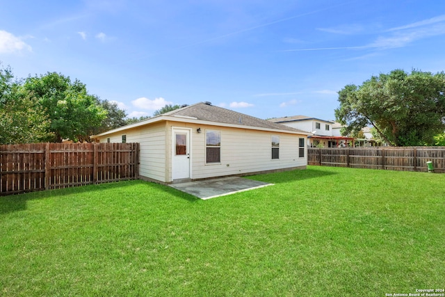 back of house featuring a yard, a patio, and a fenced backyard