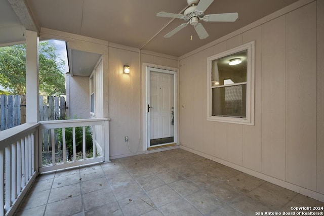 property entrance featuring ceiling fan and fence