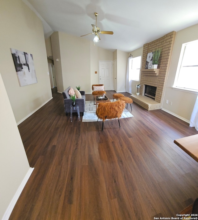 living room with a fireplace, dark hardwood / wood-style flooring, ceiling fan, and lofted ceiling