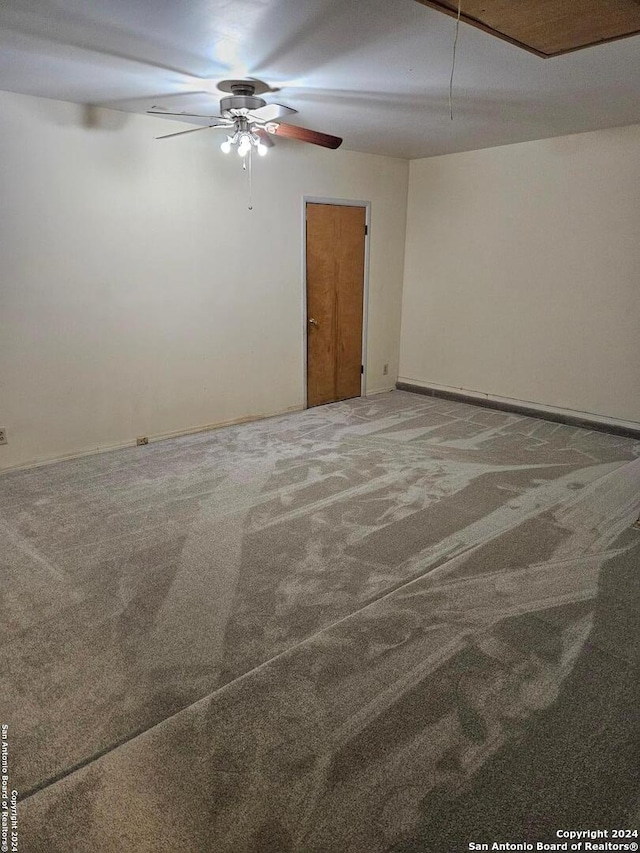 carpeted spare room featuring ceiling fan