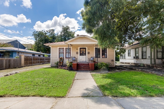 bungalow with cooling unit and a front lawn