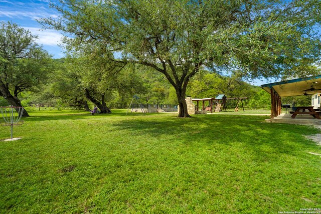 201 N Tomahawk Way, Concan, TX 78801 - view of grassy yard with a playground and ceiling fan