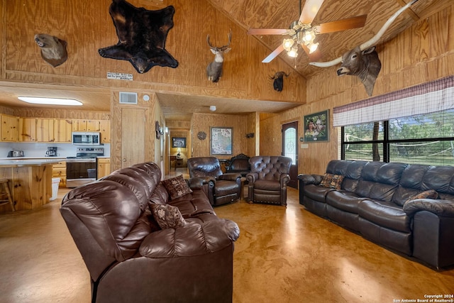 living room featuring wood walls, high vaulted ceiling, and ceiling fan